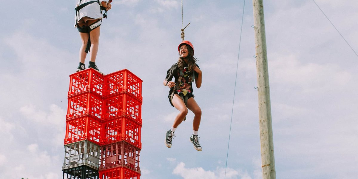 picture of teenage girls on school camp with helmet and harness doing crate stacking activity
