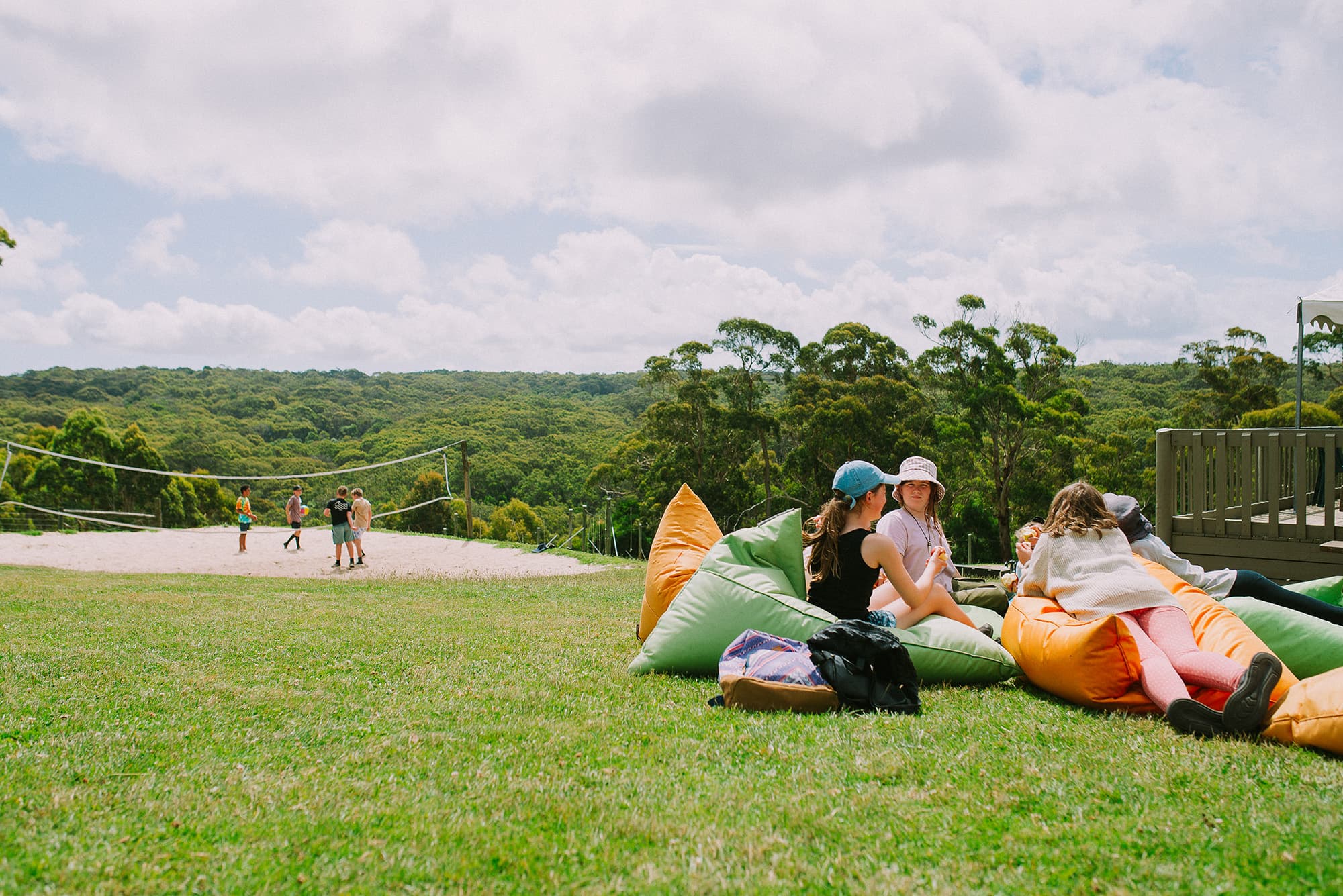 Families sitting on the grass on bean bags overlooking the valleys and adventure actvities on family open day at Golden Valleys Adventure Camp.