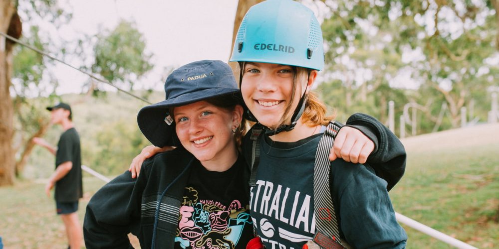 Two girls at school camp on the Mornington Peninsula, one is wearing a helmet and doing adventure activities.