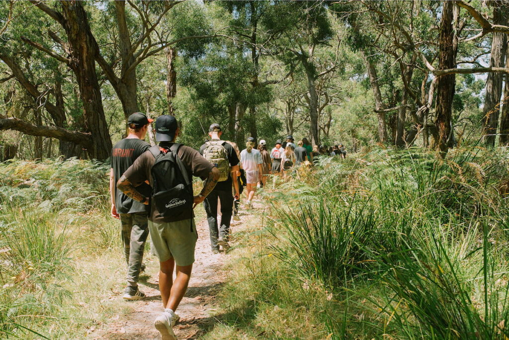 Picture of people in a line hiking through National Park bushland in beautiful nature retreat.